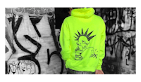 a man wearing a neon yellow hoodie with graffiti on it